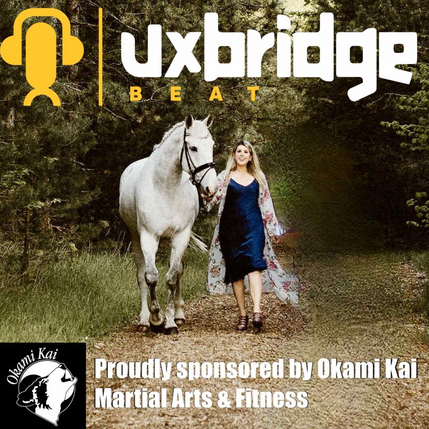 Natalie Knox walking with her horse in a forest.